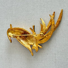 Vintage gold‑tone bird of paradise brooch with navy and green enamel accents, clear pave rhinestones, and a textured metal body, signed Sphinx with model number A2385.