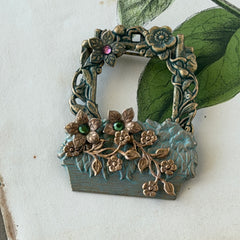 Vintage hand‑painted green and gold tone floral basket brooch with rhinestone accents, shown from multiple angles.
