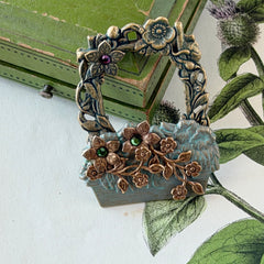 Vintage hand‑painted green and gold tone floral basket brooch with rhinestone accents, shown from multiple angles.