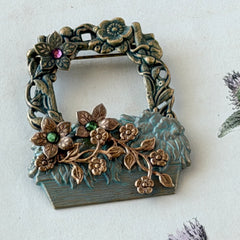 Vintage hand‑painted green and gold tone floral basket brooch with rhinestone accents, shown from multiple angles.