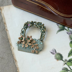 Vintage hand‑painted green and gold tone floral basket brooch with rhinestone accents, shown from multiple angles.