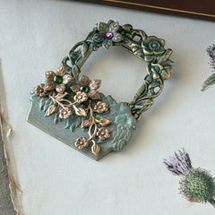 Vintage hand‑painted green and gold tone floral basket brooch with rhinestone accents, shown from multiple angles.