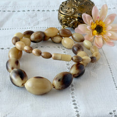 Vintage Scottish stag horn antler necklace with graduated oval beads and screw clasp, shown on display and close‑up to highlight natural horn texture and craftsmanship.