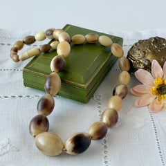 Vintage Scottish stag horn antler necklace with graduated oval beads and screw clasp, shown on display and close‑up to highlight natural horn texture and craftsmanship.