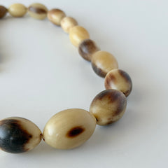 Vintage Scottish stag horn antler necklace with graduated oval beads and screw clasp, shown on display and close‑up to highlight natural horn texture and craftsmanship.