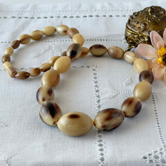 Vintage Scottish stag horn antler necklace with graduated oval beads and screw clasp, shown on display and close‑up to highlight natural horn texture and craftsmanship.