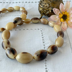 Vintage Scottish stag horn antler necklace with graduated oval beads and screw clasp, shown on display and close‑up to highlight natural horn texture and craftsmanship.