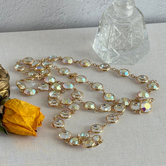 Vintage Swarovski long necklace with bezel‑set AB clear crystal coin stones in gold‑tone metal, signed with Swarovski swan hang tag.