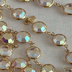 Vintage Swarovski long necklace with bezel‑set AB clear crystal coin stones in gold‑tone metal, signed with Swarovski swan hang tag.