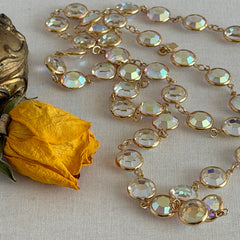 Vintage Swarovski long necklace with bezel‑set AB clear crystal coin stones in gold‑tone metal, signed with Swarovski swan hang tag.