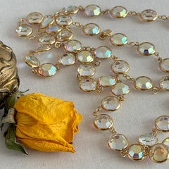 Vintage Swarovski long necklace with bezel‑set AB clear crystal coin stones in gold‑tone metal, signed with Swarovski swan hang tag.
