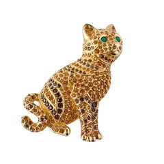 Vintage Swarovski cat brooch from the 1996 Precious Pets collection with hand‑polished gold‑plated setting, topaz and smoked topaz pavé crystals, green cabochon eyes, and honey‑brown enamel back, shown in various angles and lighting.
