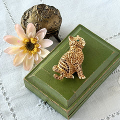 Vintage Swarovski cat brooch from the 1996 Precious Pets collection with hand‑polished gold‑plated setting, topaz and smoked topaz pavé crystals, green cabochon eyes, and honey‑brown enamel back, shown in various angles and lighting.