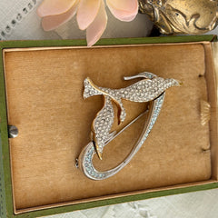 Vintage Swarovski 1999 Freedom Bird brooch with mixed gold‑ and silver‑tone metal and clear pavé crystals, shown from various angles to highlight its sculptural shape and condition.