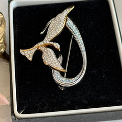 Vintage Swarovski 1999 Freedom Bird brooch with mixed gold‑ and silver‑tone metal and clear pavé crystals, shown from various angles to highlight its sculptural shape and condition.