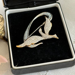 Vintage Swarovski 1999 Freedom Bird brooch with mixed gold‑ and silver‑tone metal and clear pavé crystals, shown from various angles to highlight its sculptural shape and condition.