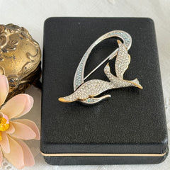 Vintage Swarovski 1999 Freedom Bird brooch with mixed gold‑ and silver‑tone metal and clear pavé crystals, shown from various angles to highlight its sculptural shape and condition.