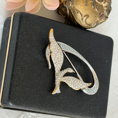 Vintage Swarovski 1999 Freedom Bird brooch with mixed gold‑ and silver‑tone metal and clear pavé crystals, shown from various angles to highlight its sculptural shape and condition.