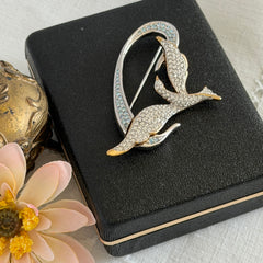 Vintage Swarovski 1999 Freedom Bird brooch with mixed gold‑ and silver‑tone metal and clear pavé crystals, shown from various angles to highlight its sculptural shape and condition.