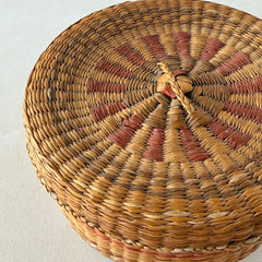 Vintage round sweetgrass basket with lid featuring a red and black woven pattern, shown from multiple angles to highlight its craftsmanship and natural texture.