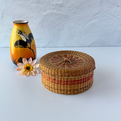 Vintage round sweetgrass basket with lid featuring a red and black woven pattern, shown from multiple angles to highlight its craftsmanship and natural texture.