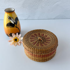 Vintage round sweetgrass basket with lid featuring a red and black woven pattern, shown from multiple angles to highlight its craftsmanship and natural texture.