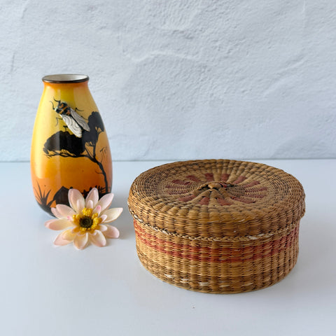 Vintage round sweetgrass basket with lid featuring a red and black woven pattern, shown from multiple angles to highlight its craftsmanship and natural texture.
