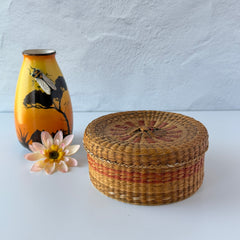 Vintage round sweetgrass basket with lid featuring a red and black woven pattern, shown from multiple angles to highlight its craftsmanship and natural texture.