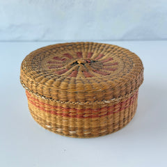 Vintage round sweetgrass basket with lid featuring a red and black woven pattern, shown from multiple angles to highlight its craftsmanship and natural texture.