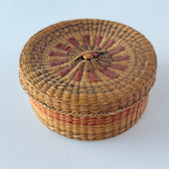 Vintage round sweetgrass basket with lid featuring a red and black woven pattern, shown from multiple angles to highlight its craftsmanship and natural texture.