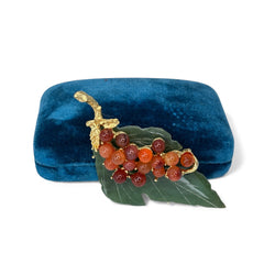 Vintage Swoboda brooch featuring a carved green jade leaf and a cluster of round carnelian berries set in gold‑tone metal, shown from multiple angles to highlight its details and signature.