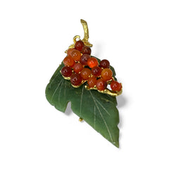Vintage Swoboda brooch featuring a carved green jade leaf and a cluster of round carnelian berries set in gold‑tone metal, shown from multiple angles to highlight its details and signature.