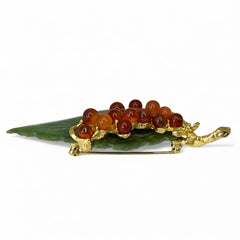 Vintage Swoboda brooch featuring a carved green jade leaf and a cluster of round carnelian berries set in gold‑tone metal, shown from multiple angles to highlight its details and signature.