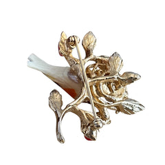 Vintage Swoboda bird nest brooch with a painted bone bird, faux pearl eggs, coral‑colored stone chips, and gold‑tone metal branch detailing.
