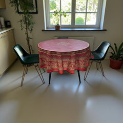 Round coated cotton tablecloth in deep red and golden yellow, featuring ornate Provençal floral and geometric patterns