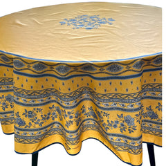 Round coated cotton tablecloth in sunny yellow and deep blue, featuring alternating Provençal floral and geometric bands