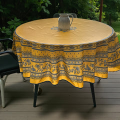 Round coated cotton tablecloth in sunny yellow and deep blue, featuring alternating Provençal floral and geometric bands