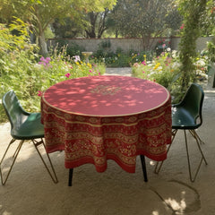 Round coated cotton tablecloth in deep red and golden yellow, featuring ornate Provençal floral and geometric patterns