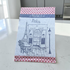 Light blue French tea towel with red gingham borders and a navy illustration of a Paris café and Eiffel Tower, by Coucke.