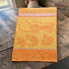 Yellow and orange French tea towel with woven lemon and citrus slice motifs and decorative borders, by Coucke.