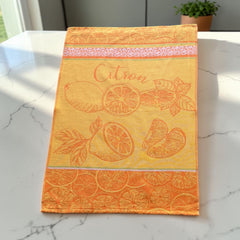 Yellow and orange French tea towel with woven lemon and citrus slice motifs and decorative borders, by Coucke.