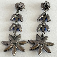 Pair of vintage 1980s Thelma Deutsch clip‑on earrings with deep blue rhinestones in a cascading dangle design set in dark gunmetal‑tone metal.