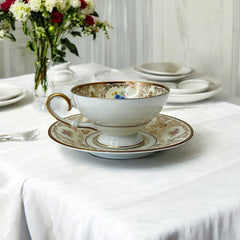 Vintage Tirschenreuth Bavaria demi-tasse and saucer set in cream porcelain with ornate floral clusters and gold scrollwork; footed teacup with gilded handle and rim, saucer marked with crown and shield logo and red glaze number 2284.