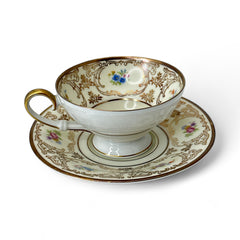 Vintage Tirschenreuth Bavaria demi-tasse and saucer set in cream porcelain with ornate floral clusters and gold scrollwork; footed teacup with gilded handle and rim, saucer marked with crown and shield logo and red glaze number 2284.