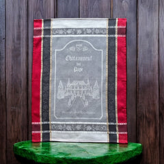 Provence tea towel featuring Châteauneuf-du-Pape winery chateau design with gray background and red and brown striped borders. Made of 100% cotton, ideal for wine-inspired kitchen decor and rustic elegance.