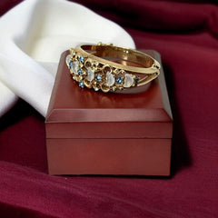 Vintage Trifari “Clair de Lune” bracelet by Alfred Philippe, gold-plated hinged bangle with crescent-shaped opalized faux moonstones, sapphire blue and clear rhinestones, shown in various lighting and angles to highlight design and craftsmanship