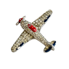 Vintage Trifari airplane brooch with clear stones, red nose detail, and blue enamel accents.