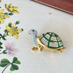 Vintage gold tone turtle brooch with green enamel shell and clear rhinestones, viewed from front and back.