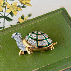 Vintage gold tone turtle brooch with green enamel shell and clear rhinestones, viewed from front and back.
