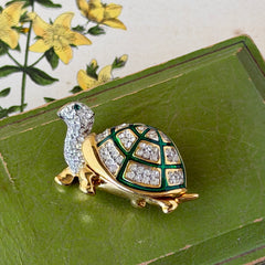 Vintage gold tone turtle brooch with green enamel shell and clear rhinestones, viewed from front and back.